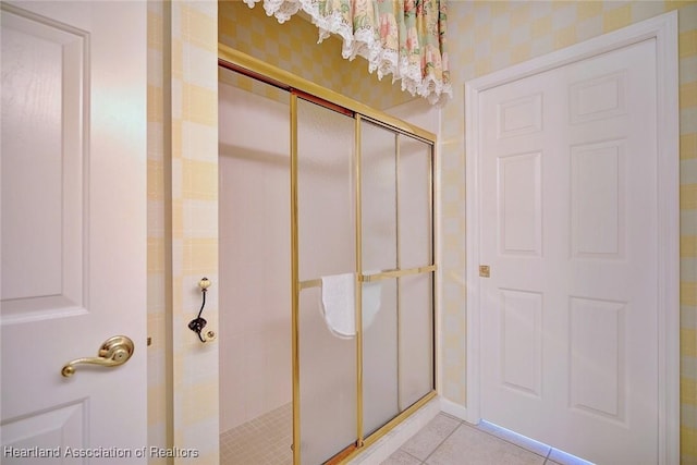 bathroom with a stall shower and tile patterned flooring