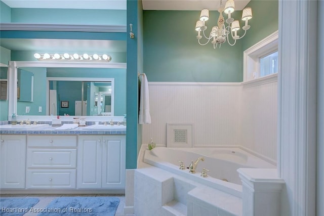 full bathroom with a sink, a chandelier, a bath, and double vanity