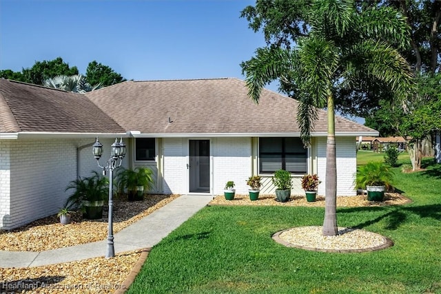 4 Rosewood Dr N, Lake Placid, FL 33852 - ranch-style home with brick siding, a front lawn, and roof with shingles