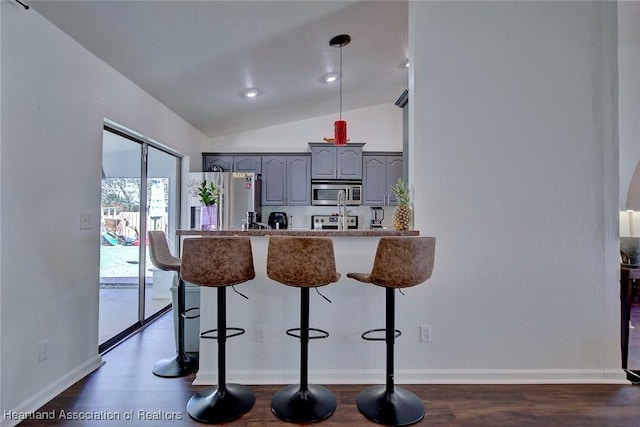2200 W Geneva Rd, Avon Park, FL 33825 - kitchen with appliances with stainless steel finishes, gray cabinetry, vaulted ceiling, a kitchen breakfast bar, and a peninsula