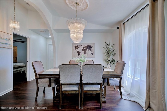 2200 W Geneva Rd, Avon Park, FL 33825 - dining room featuring a chandelier, vaulted ceiling, arched walkways, baseboards, and dark wood-style floors