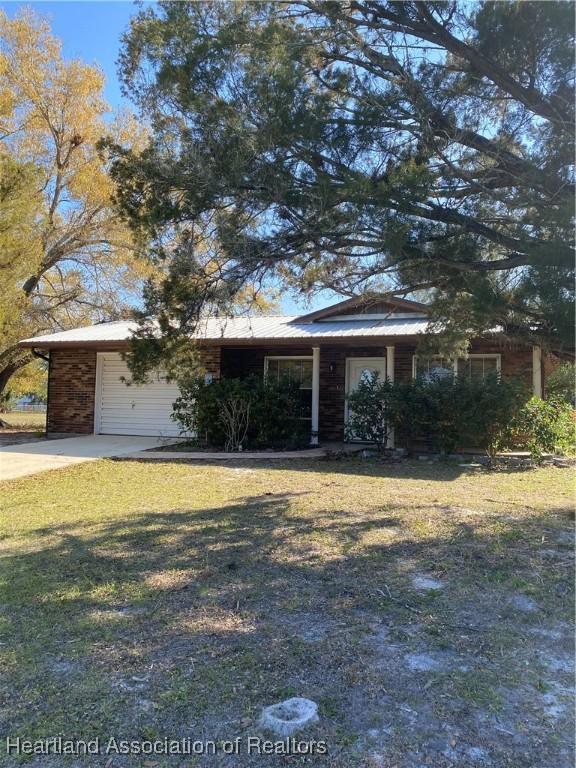 single story home with a garage and a front lawn