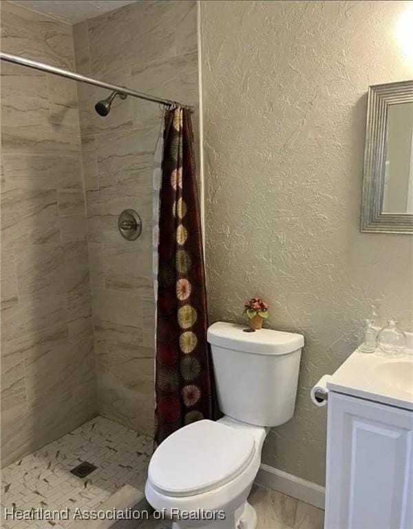 bathroom featuring vanity, toilet, and walk in shower