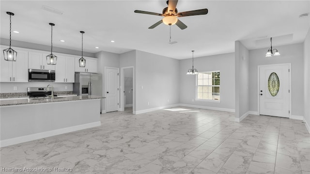 19 N Irvington Rd, Avon Park, FL 33825 - kitchen with pendant lighting, light stone countertops, white cabinetry, and appliances with stainless steel finishes