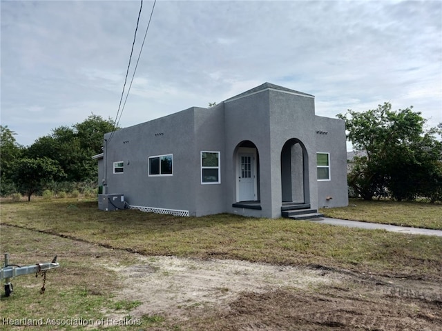 adobe home with a front yard and cooling unit