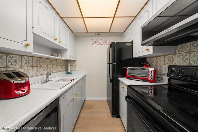 2111 Lakeview Dr Unit 1A, Sebring, FL 33870 - kitchen featuring black electric range oven, a sink, white cabinetry, and light countertops