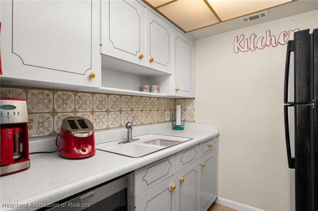 2111 Lakeview Dr Unit 1A, Sebring, FL 33870 - kitchen featuring a sink, freestanding refrigerator, light countertops, decorative backsplash, and open shelves