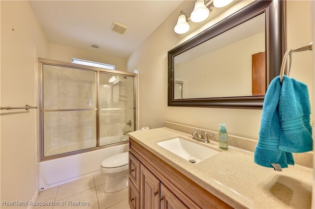 full bathroom with combined bath / shower with glass door, vanity, tile patterned floors, and toilet