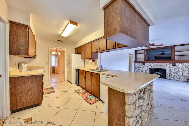 kitchen featuring kitchen peninsula, white appliances, ceiling fan with notable chandelier, sink, and light tile patterned floors