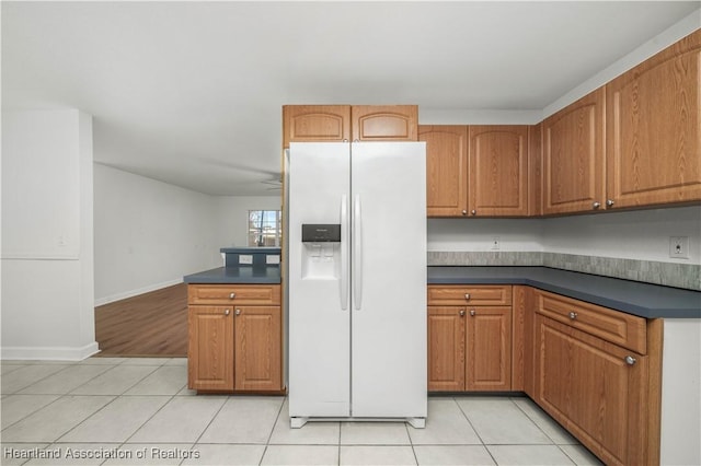 kitchen with ceiling fan, light tile patterned flooring, and white refrigerator with ice dispenser