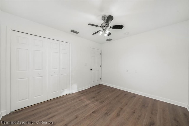 unfurnished bedroom featuring a closet, ceiling fan, and dark wood-type flooring