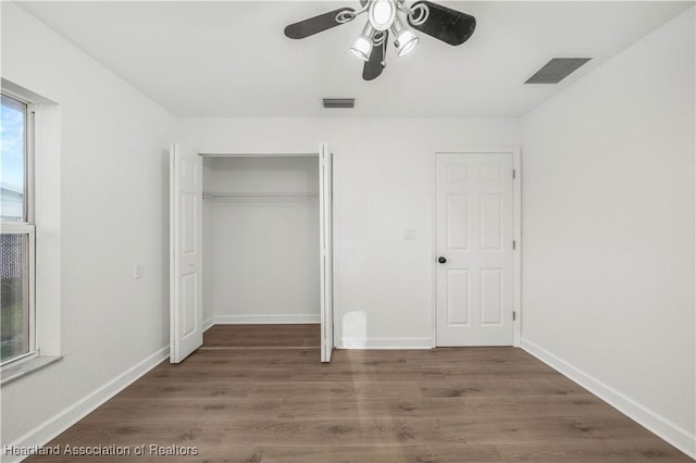 unfurnished bedroom with a closet, ceiling fan, and dark hardwood / wood-style flooring