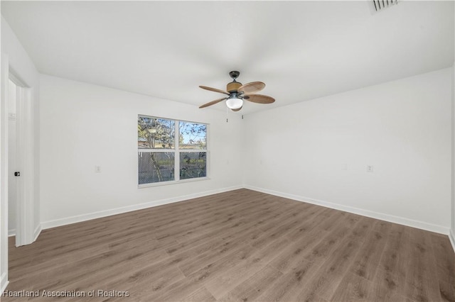 spare room with ceiling fan and dark wood-type flooring