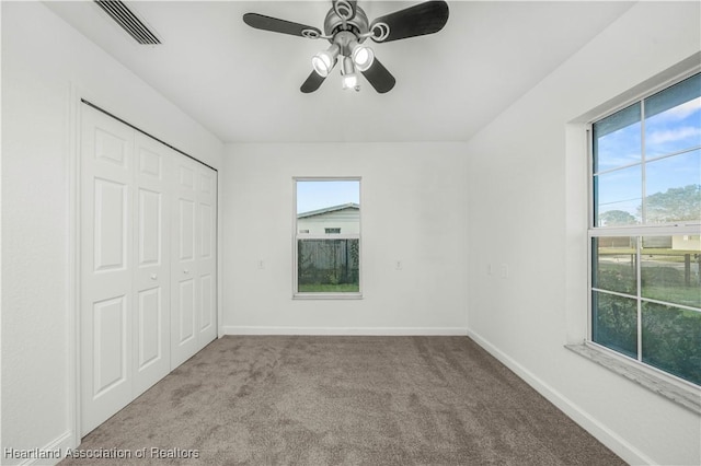 unfurnished bedroom featuring light colored carpet, a closet, and ceiling fan