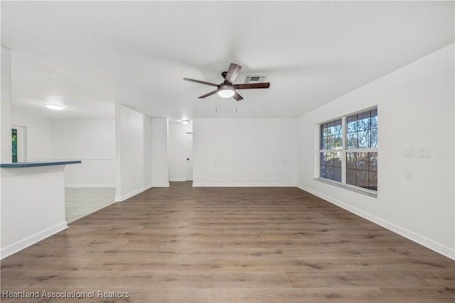 unfurnished living room featuring wood-type flooring and ceiling fan