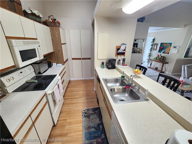 kitchen featuring white cabinetry, sink, white appliances, and light wood-type flooring