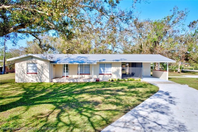 ranch-style house featuring covered porch, a front lawn, and a carport