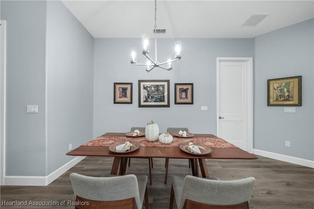 dining space featuring dark hardwood / wood-style flooring and a notable chandelier