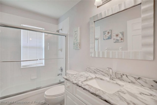 full bathroom with vanity, toilet, and enclosed tub / shower combo