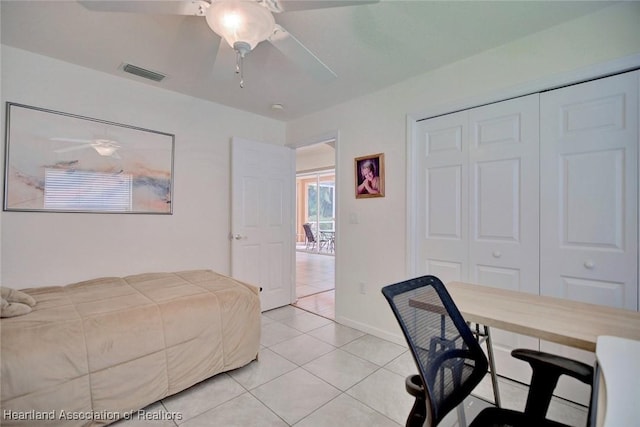 tiled bedroom featuring ceiling fan and a closet