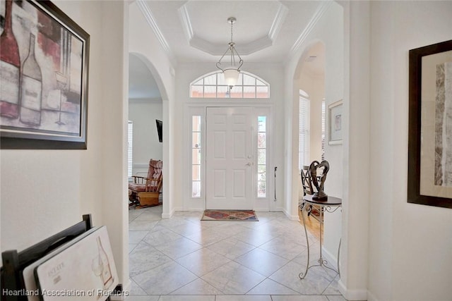 entrance foyer with ornamental molding and a tray ceiling