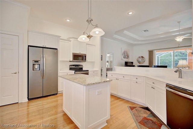 kitchen with white cabinets, decorative light fixtures, sink, and appliances with stainless steel finishes