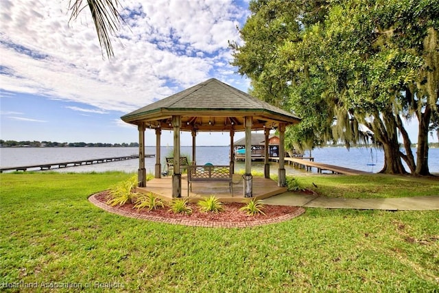 dock area with a lawn, a gazebo, and a water view