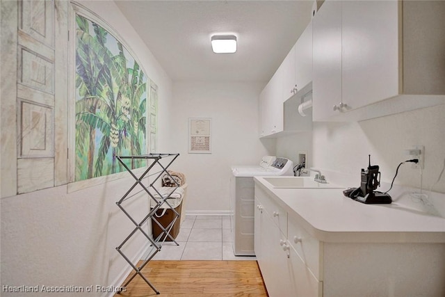 kitchen featuring washing machine and dryer, white cabinetry, and light tile patterned flooring