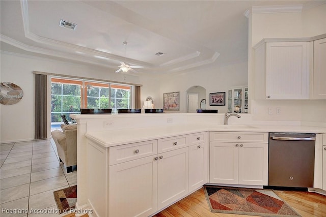 kitchen with a raised ceiling, kitchen peninsula, dishwasher, and sink