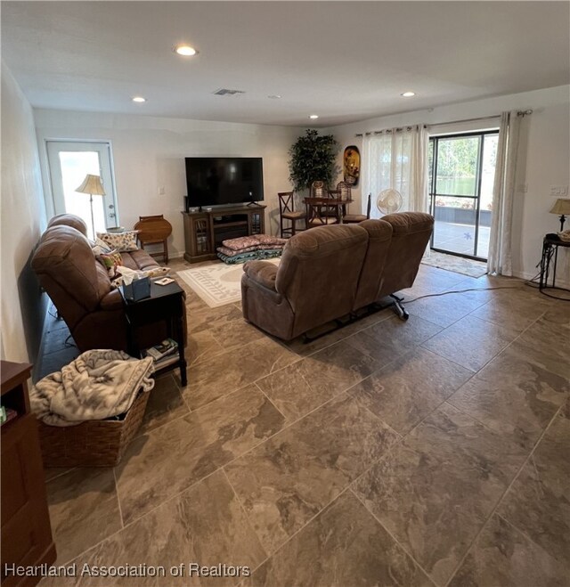 living area with recessed lighting, visible vents, and baseboards