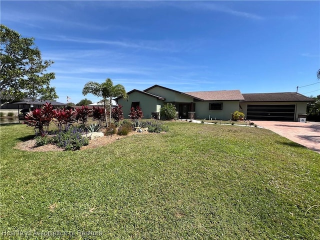 view of front of house with a front lawn, a garage, driveway, and stucco siding