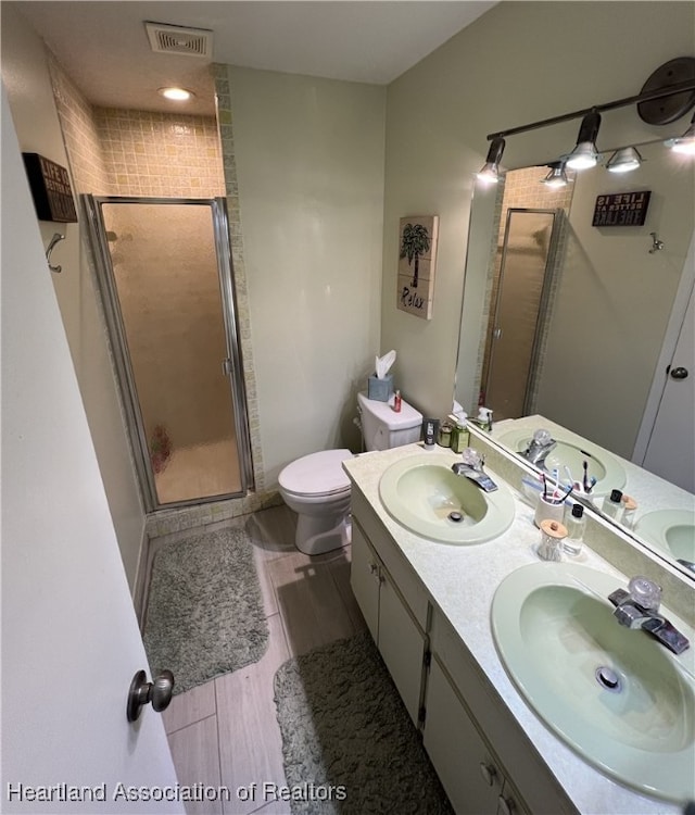 bathroom with a stall shower, visible vents, and a sink