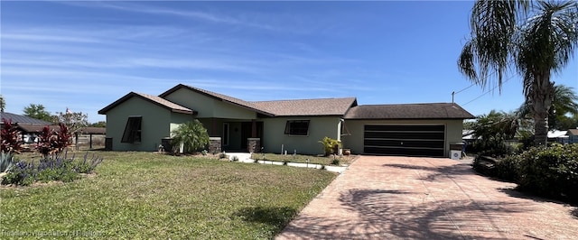 view of front facade with a garage, concrete driveway, a front yard, and stucco siding