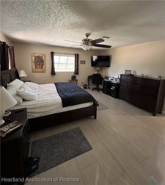 bedroom featuring a textured ceiling and a ceiling fan