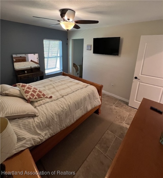 bedroom with a ceiling fan and baseboards