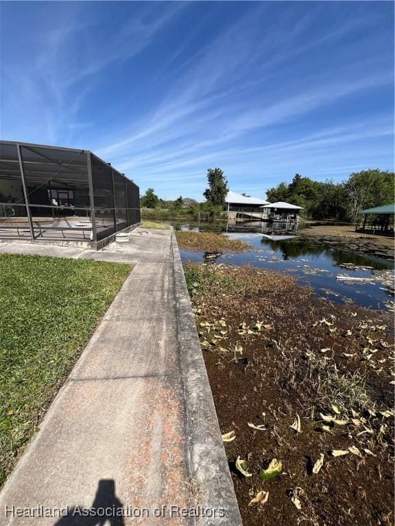 view of yard with glass enclosure and a water view