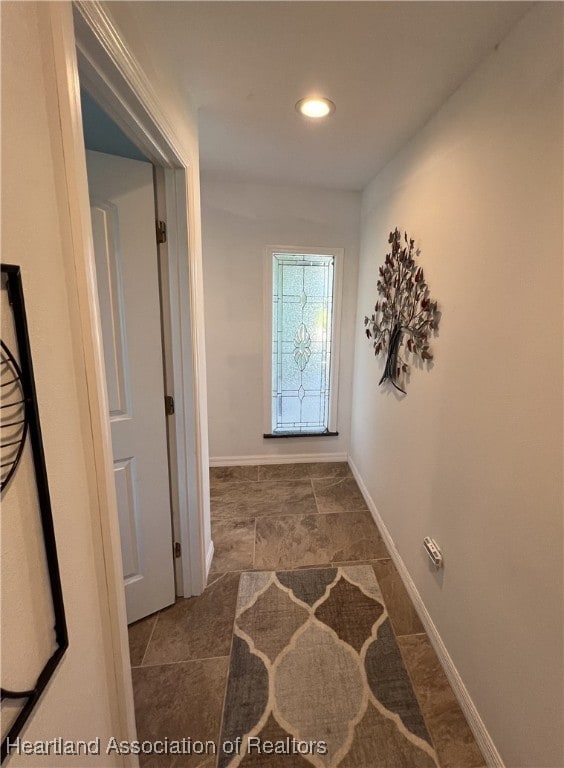 hall featuring recessed lighting and baseboards