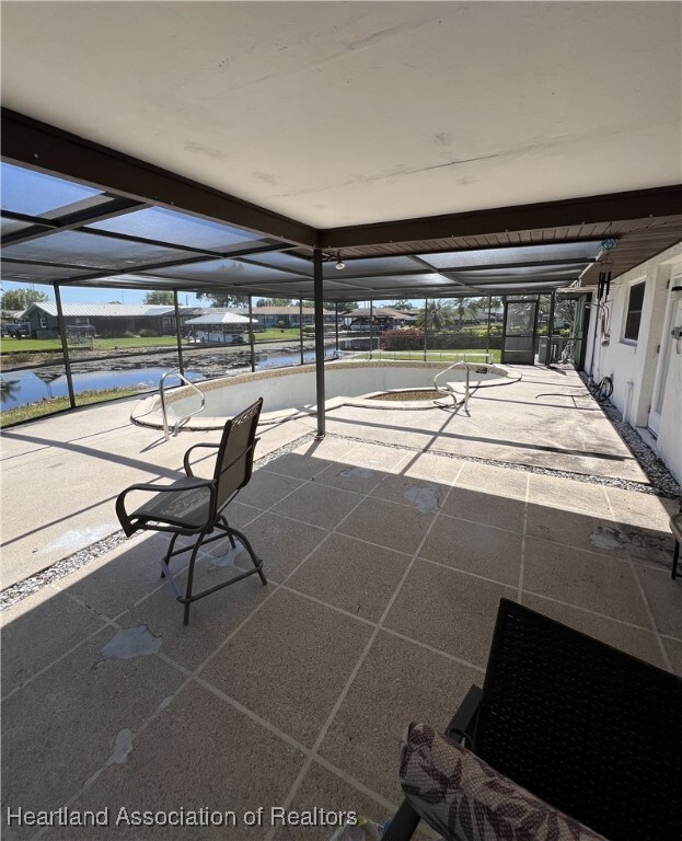 view of patio / terrace with a lanai and a water view