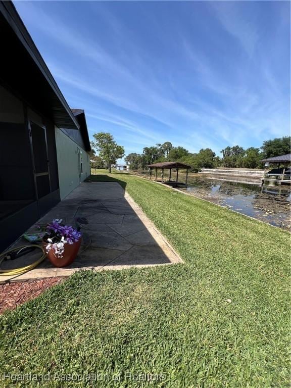 view of yard with a gazebo, a patio, and a water view