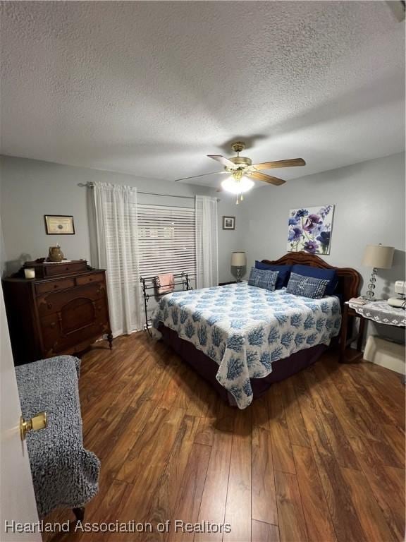 bedroom with a textured ceiling, dark wood finished floors, and a ceiling fan