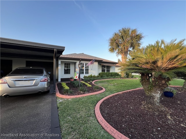 ranch-style home with driveway and a front yard