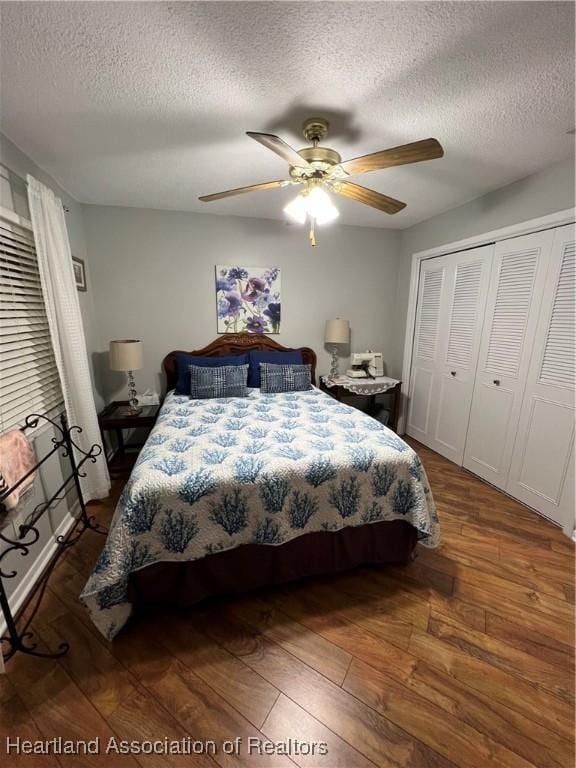 bedroom with dark wood-style floors, a textured ceiling, a ceiling fan, and a closet