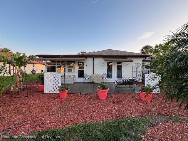 view of front of home featuring roof with shingles and stucco siding