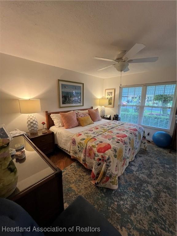 bedroom with a ceiling fan and a textured ceiling