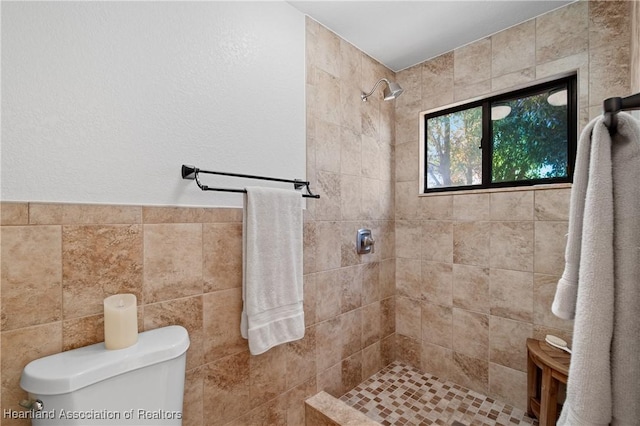bathroom featuring a tile shower and toilet