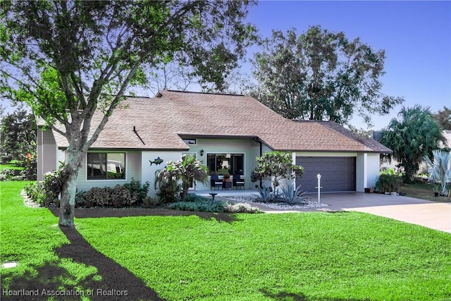 single story home with stucco siding, driveway, a front yard, and a garage