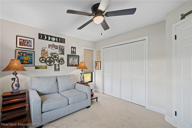 living room featuring carpet floors, baseboards, and ceiling fan