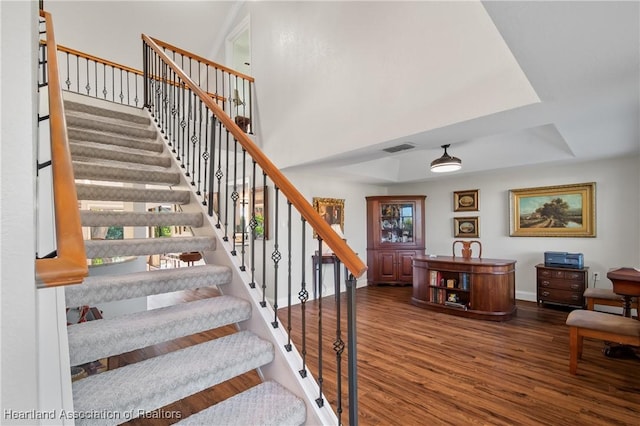 stairs with visible vents, baseboards, and wood finished floors