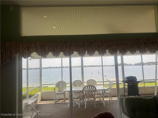 sunroom with plenty of natural light and a water view