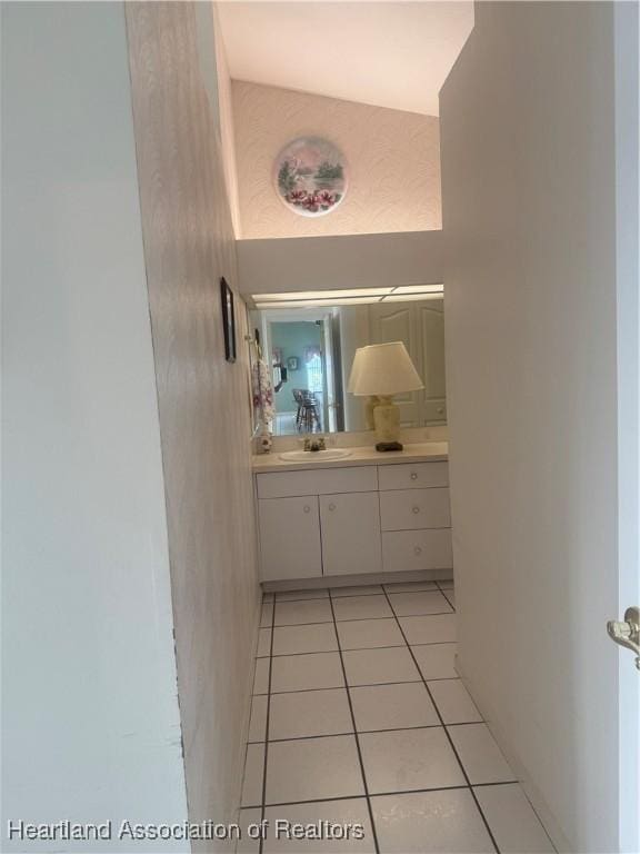 hallway with light tile patterned floors and a sink